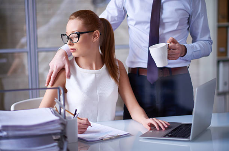 Man with hand on woman's shoulder in office environment