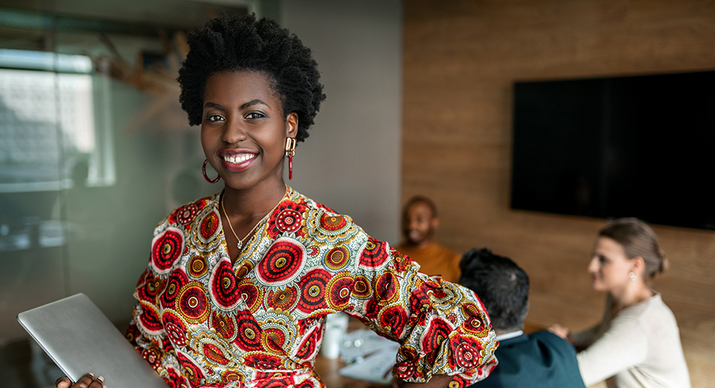 Young smiling professional business woman holding laptop, coworkers hold a meeting