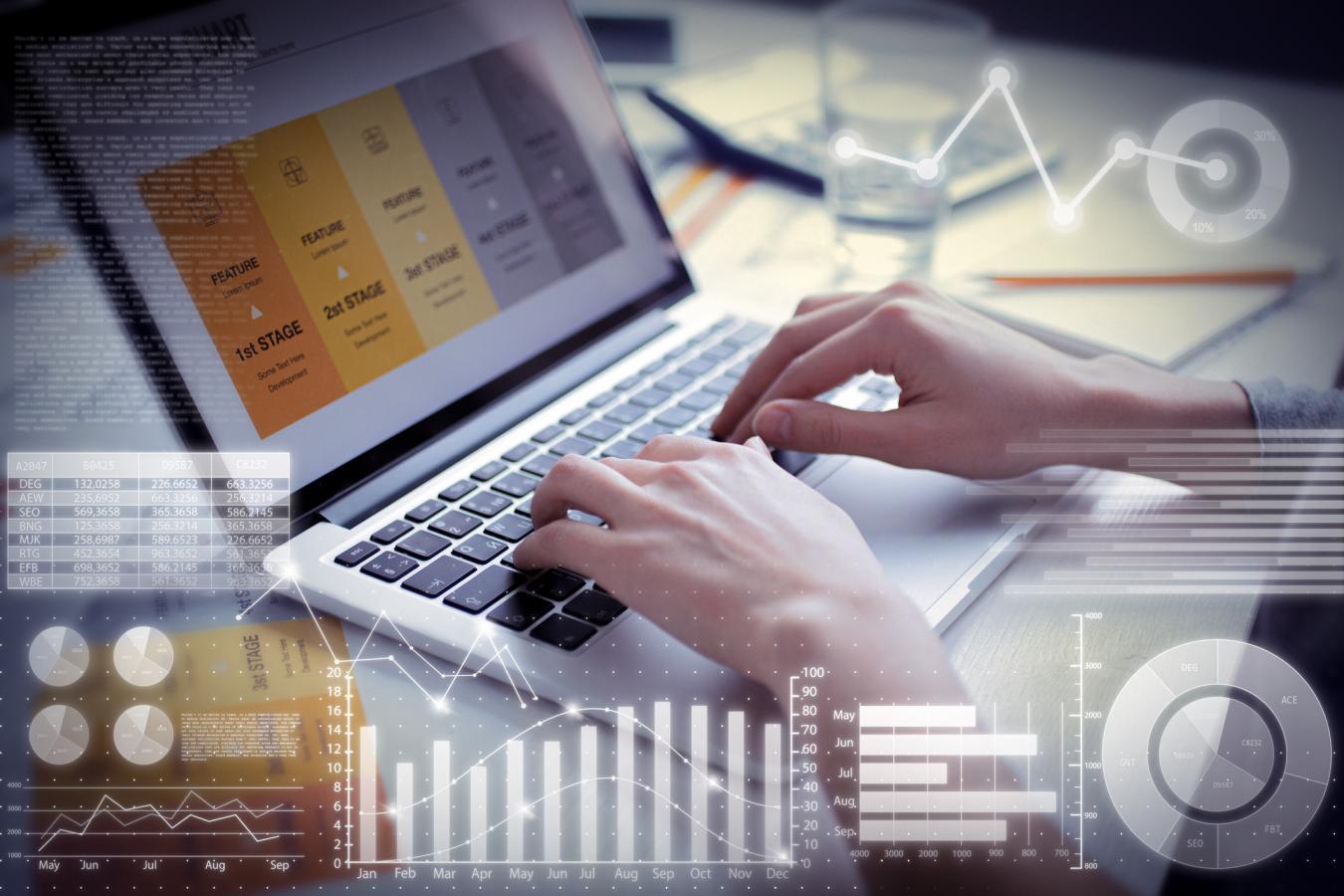 Image of hands on a keyboard with a graphic overlay of charts and graphs and numbers.