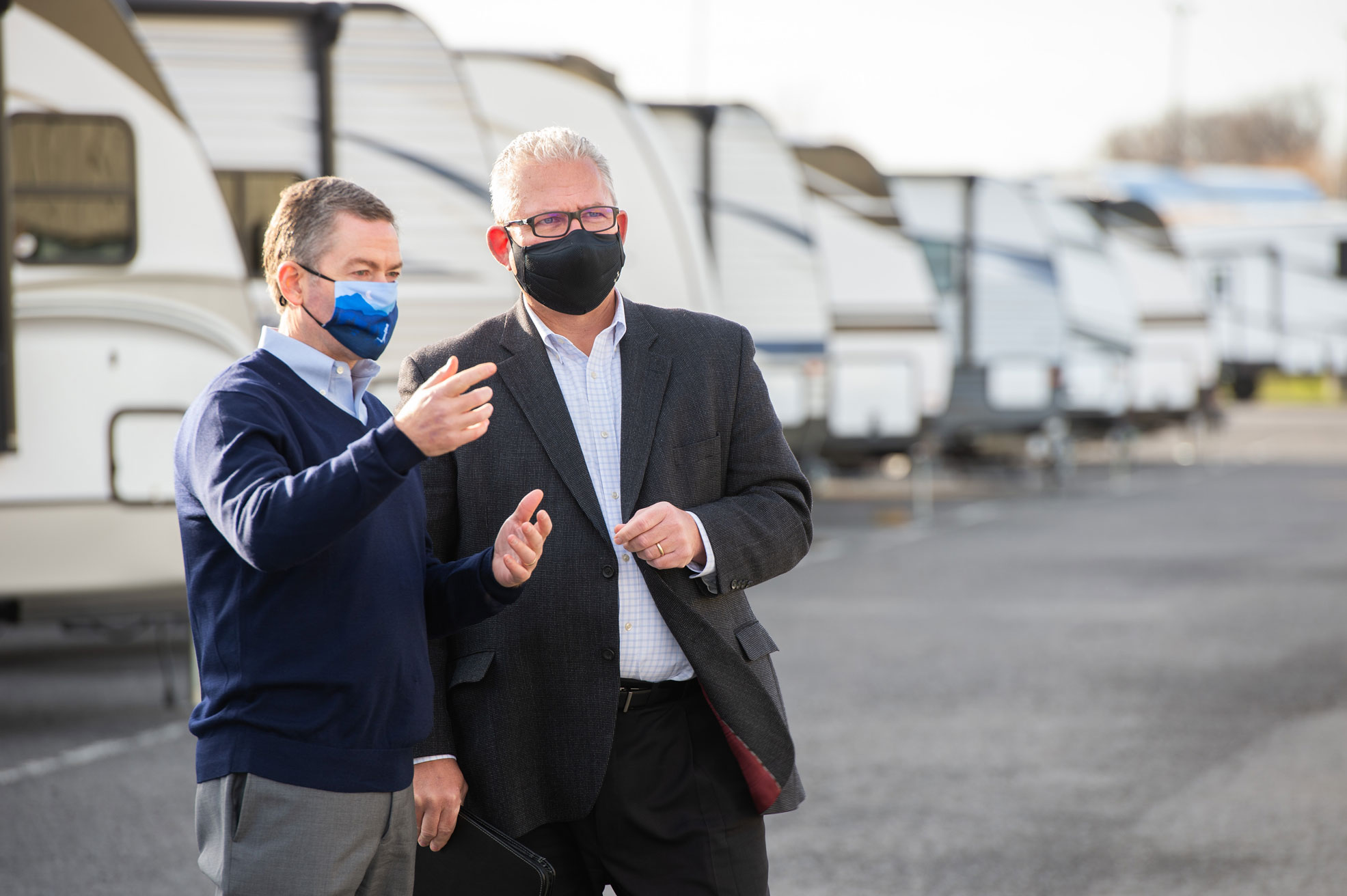 BST advisors visiting a client location and talking outside near a row of RV's