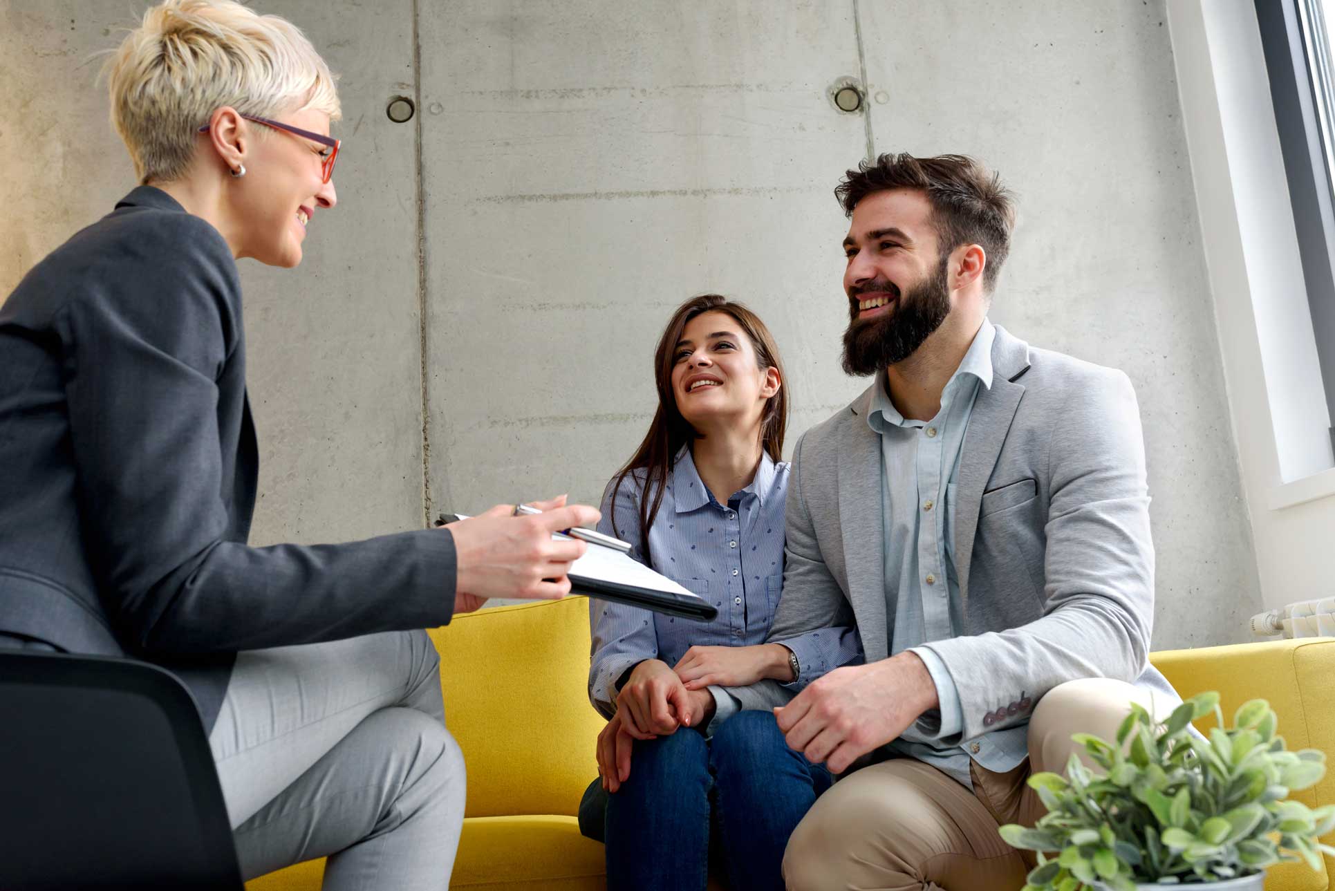 A couple sits with an advisor and discuss something on paper 